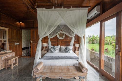 a bedroom with a bed with a canopy at Uma Sebatu Villa Ubud in Tegalalang