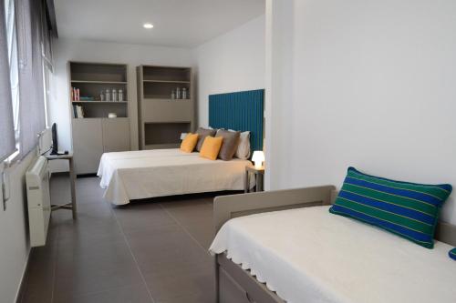 een hotelkamer met 2 bedden, een bureau en een kamer bij Lab Hostel Nazare in Nazaré