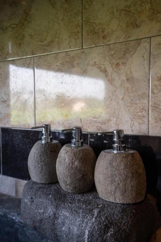 a couple of soap dispensers sitting on top of a sink at Uma Sebatu Villa Ubud in Tegalalang