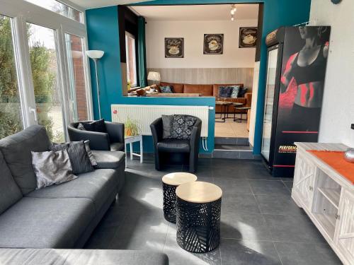 a living room with a couch and chairs and a kitchen at Les Bastinettes in Stoumont