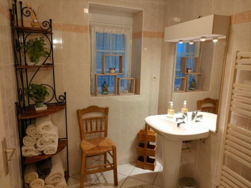 uma casa de banho com um lavatório branco e uma cadeira em Ker Fuffle em Plougoulm