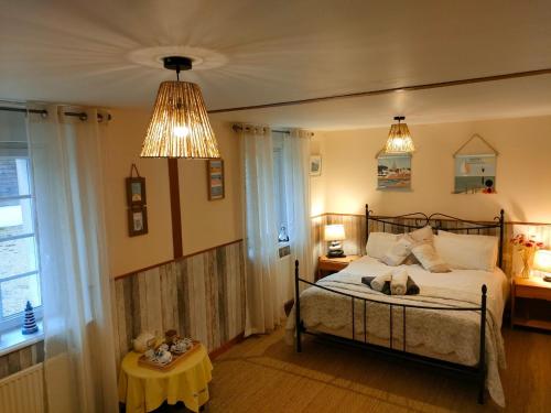 um quarto com uma cama, uma mesa e duas luzes em Ker Fuffle em Plougoulm