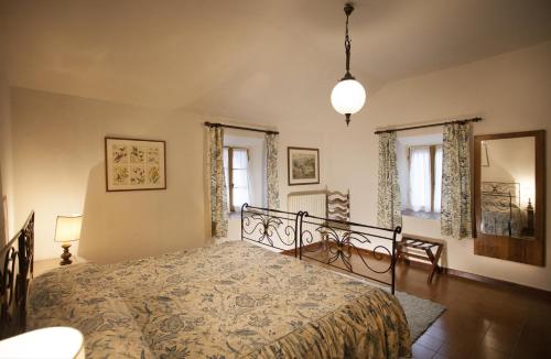 a bedroom with a bed and two windows at Agriturismo Cavazzone in Regnano