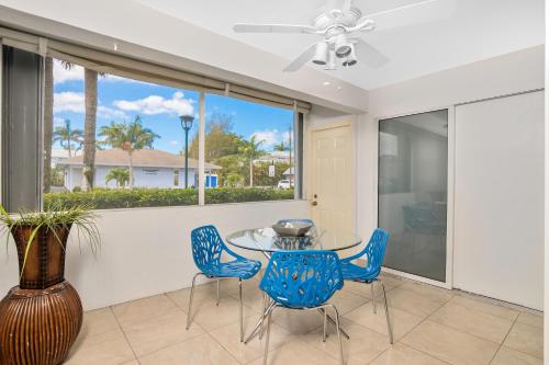 a dining room with a glass table and blue chairs at Downtown Starfish 807 in Naples
