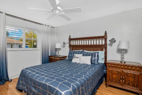 Schlafzimmer mit einem blauen Bett und einem Deckenventilator in der Unterkunft Downtown Starfish 807 in Naples
