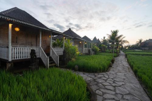 a house with a pathway next to a field of grass at Uma Sebatu Villa Ubud in Tegalalang