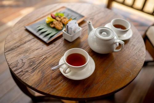een tafel met twee kopjes thee en een bord eten bij Sunia Jungle Ubud View by EPS in Tegalalang