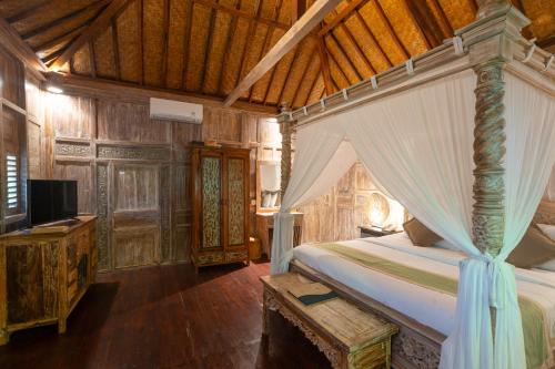 a bedroom with a bed and a television in it at Uma Sebatu Villa Ubud in Tegalalang