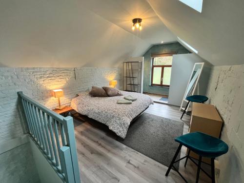 um quarto com uma cama e dois bancos em Cosy little house em Kraainem