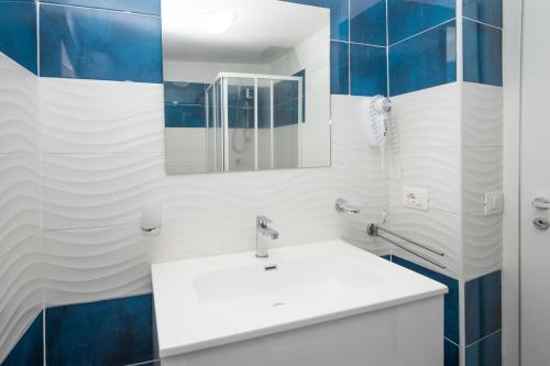 uma casa de banho com um lavatório branco e um espelho. em B&B Saturno em Marina di Camerota
