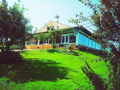 ein Haus auf einem grasbewachsenen Hügel mit einem Gebäude in der Unterkunft Surfhousegerra in San Vicente de la Barquera