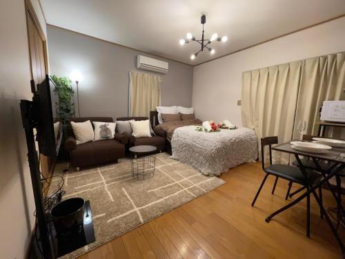 a living room with a couch and a table at Best Shinjuku Modern Full-furnished Apartment1 ONLY 2min to Shinjuku by Train in Tokyo