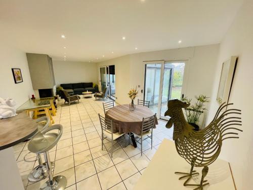- un salon avec une table et une statue de poulet dans l'établissement Maison T2 de 70 m2 avec jardin et véranda, à Rignac