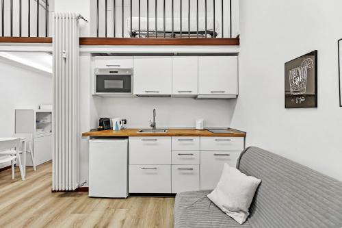 een keuken met witte kasten en een aanrechtblad bij Loft Daiquiri nel Centro di Milano, via Sottocorno, Porta Vittoria in Milaan