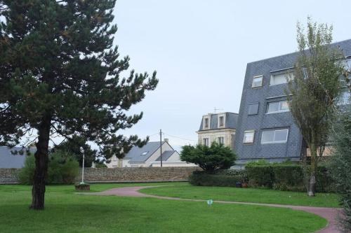 una casa con un albero e un prato di Beau F2, vue sur mer, à deux pas de Courseulles. a Bernières-sur-Mer