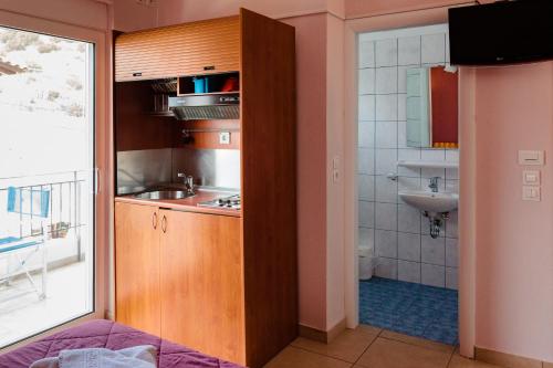 a small kitchen with a sink and a bathroom at Hotel Apanema in Vivari