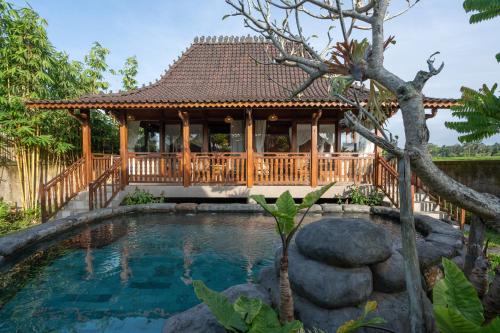 a pool with a gazebo and a house at Uma Sebatu Villa Ubud in Tegalalang