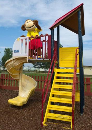 a girl is standing on a slide on a playground at Skye Breaks in Sheerness