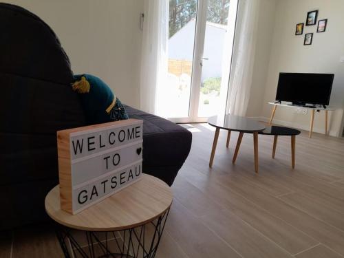 a welcome to calisan sign on a table in a living room at Le Logis de Gatseau in Les Mathes