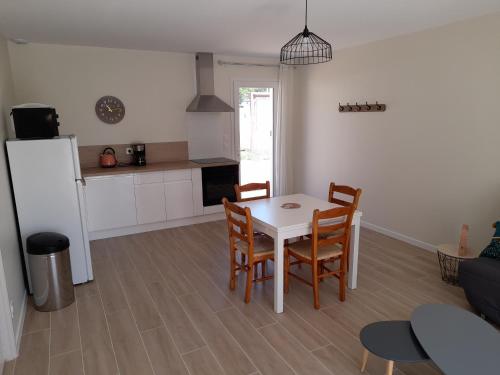 une cuisine et une salle à manger avec une table et des chaises dans l'établissement Le Logis de Gatseau, aux Mathes