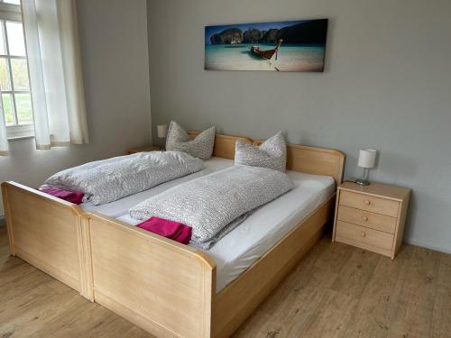 ein Bett mit einem Holzrahmen in einem Zimmer in der Unterkunft Pension Bootshaus in Weißenfels