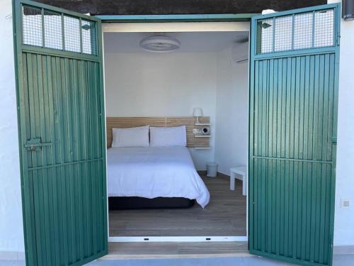 1 dormitorio con 1 cama con puertas correderas verdes en The Nook at Monda, en Monda