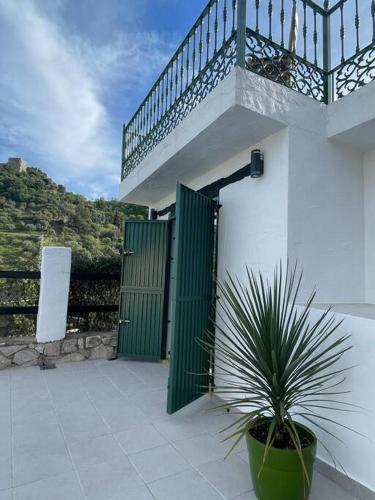 a house with a green gate and a potted plant at The Nook at Monda in Monda