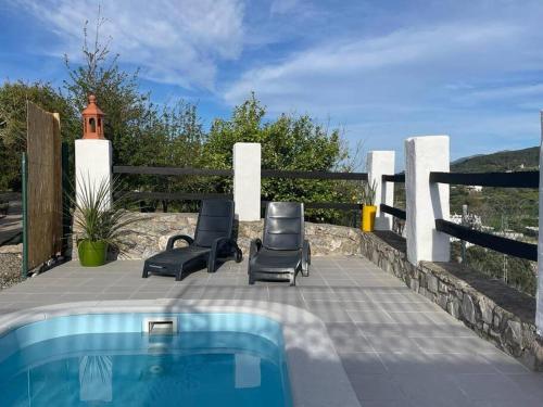 a patio with two chairs and a swimming pool at The Nook at Monda in Monda