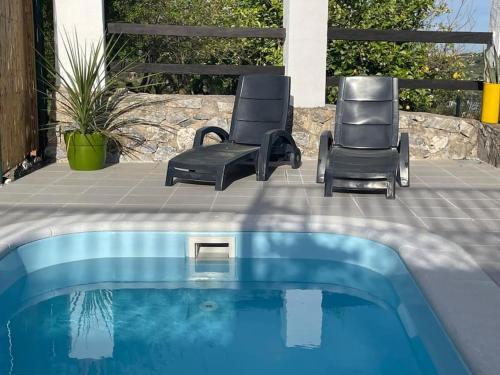 two chairs sitting next to a swimming pool at The Nook at Monda in Monda