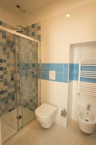 a bathroom with a toilet and a shower and a sink at Leone Suites Toledo in Naples