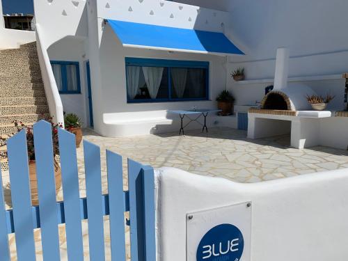 a white and blue fence in front of a house at Blue Sea Villa & Apartments in Makry Gialos