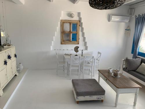 a white living room with a table and chairs at Blue Sea Villa & Apartments in Makry Gialos
