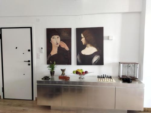 a kitchen with three paintings on the wall at Minimal apartment by the beach in Korinthos