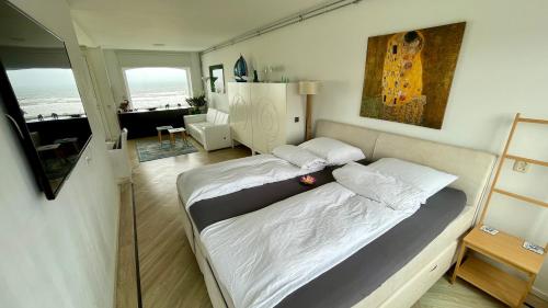 ein Schlafzimmer mit einem großen Bett und ein Wohnzimmer in der Unterkunft Beach Apartments Seaview Plus Parking in Zandvoort