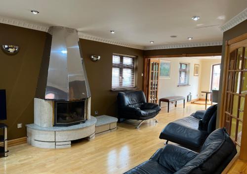 a living room with a couch and a fireplace at Luxury Canterbury Holiday Home Sleeps Ten Wifi in Canterbury