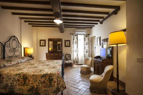 a bedroom with a bed and a desk and chairs at Agriturismo Cavazzone in Regnano