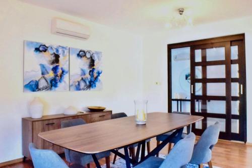 a dining room with a wooden table and blue chairs at Ilios Villa in Larnaca