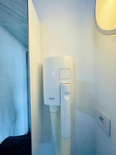 un distributeur de savon dans l'angle d'une pièce dans l'établissement Residence Louis Petite Maison, à Bains-les-Bains