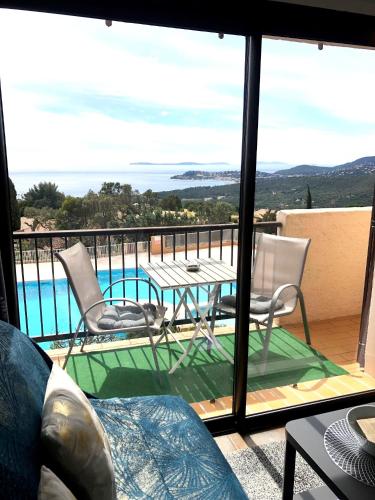 a view of a balcony with a table and chairs at STUDIO POOL HOUSE MDT 2 ETOILES VUE MER PANORAMIQUE AMAZING SEA VIEW WIFI LINGE LINEN INCLUT AIRCONDITIOn in La Croix-Valmer