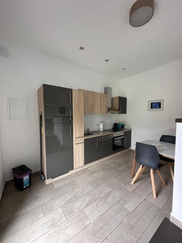 a kitchen with a refrigerator and a table in a room at Apartments am Moselufer in Bruttig-Fankel