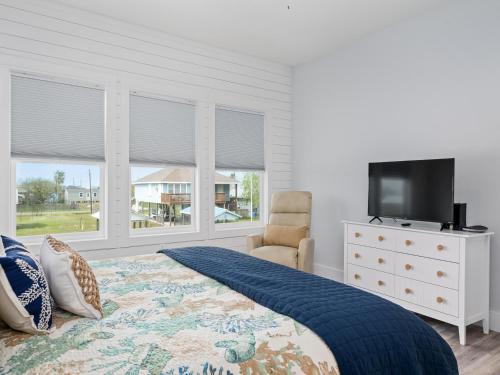 - une chambre avec un lit, une télévision et des fenêtres dans l'établissement Circle P Coastal, à Rockport