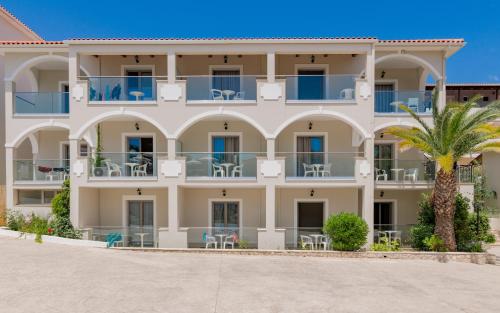 a large building with a palm tree in front of it at Katerina Palace Studio 1 in Argassi