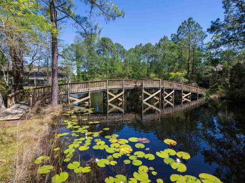 a wooden bridge over a pond with lily pads at 30A Rise and Shine in Seagrove Beach