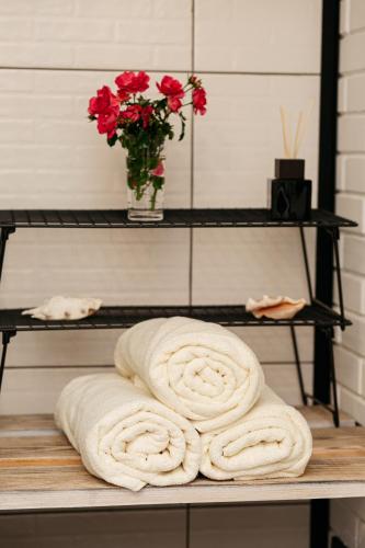 a towel on a shelf with a vase of roses at loft apartments OLD MILL in Sarny
