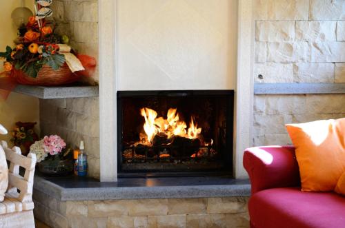 a fireplace in a living room with a fire at B&B Dimora dell' Etna in Milo
