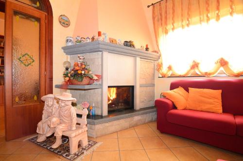 a living room with a fireplace and a red couch at B&B Dimora dell' Etna in Milo