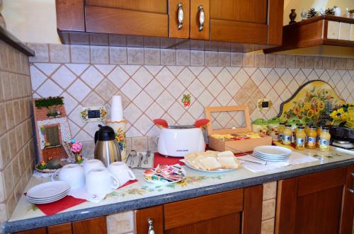 a kitchen counter with plates and utensils on it at B&B Dimora dell' Etna in Milo