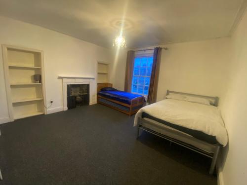 a bedroom with a bed and a fireplace and a window at Southgate Lodge - Single/Twin, Double and Family rooms in Kings Lynn