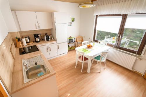 a small kitchen with a table and a sink at Haus Kallin in Idar-Oberstein