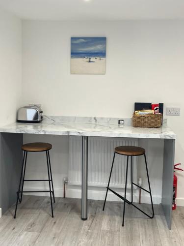 a counter with two stools and a counter top at Mayfair, Tintagel 3 bed sleeps 6 in Tintagel